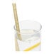 A Greenprint natural agave giant straw in a glass of water with a lemon slice.