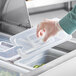 A gloved hand using a Vigor translucent polypropylene lid to cover a plastic food container.
