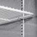 A metal shelf with a metal rod inside a Beverage-Air stainless steel reach-in freezer.