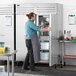 A man opening a Beverage-Air stainless steel reach-in freezer.