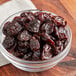 A bowl of dried tart pitted cherries on a table.