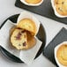 A close up of a muffin with dried tart cherries on top.