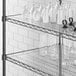 Clear PVC shelf liner on a Regency shelf holding white vases and glasses.