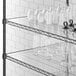 A Regency shelf with clear PVC liner holding glass vases and glasses.