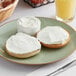 A plate with a bagel and Philadelphia Reduced Fat Cream Cheese Spread on it.