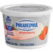 A white and red Philadelphia Strawberry Cream Cheese spread tub.