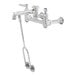 A silver T&S wall mount service sink faucet with a handle and hose.