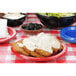 A blue plastic plate of fried chicken with Chef's Companion country gravy on a table with a red and white checkered tablecloth.