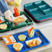 A right-handed blue melamine tray with 6 compartments holding food and a fork.