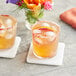 A glass of Tamarind juice with ice and an orange slice.