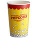 A yellow and red paper cup with the words "freshly popped popcorn" on it.