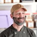 A man wearing a Choice black nylon beard net and a hat over his beard.