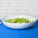 A white GET Siciliano bowl of salad on a table.