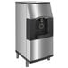A silver Manitowoc touchless ice dispenser with a black door.