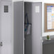 A Regency grey single tier locker with a blue and white striped bag inside.