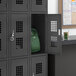 A black locker with a green backpack inside.