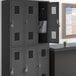 A black Regency locker with two wide doors, one open to reveal a blue and white striped bag inside.