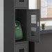 A Regency black metal locker with a backpack inside.
