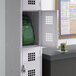 A Regency single tier locker with a green backpack inside.