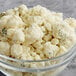 A bowl of cauliflower with Follow Your Heart Dairy-Free Vegan Crumbled Bleu Cheese on top.