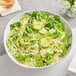 A bowl of salad with avocado and Follow Your Heart Dairy-Free Vegan Parmesan Cheese.
