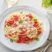 A plate of pasta with tomato sauce and Follow Your Heart vegan grated parmesan cheese.