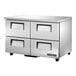 A silver True undercounter refrigerator with black handles.