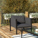A Flash Furniture charcoal patio chair with storage pockets on a table on an outdoor patio.