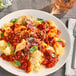 A plate of pasta with Vine Ripe Whole Peeled Tomatoes in juice and cheese.
