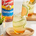 A close-up of a Torani Cantaloupe Flavoring Syrup bottle on a white surface.