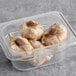 A plastic container of whole black garlic bulbs.