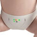 A white baby manikin wearing a diaper with green and red lights.