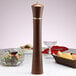 A Chef Specialties Pueblo pepper mill on a table with a plate of food.