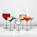 A group of Della Luce Astro red wine glasses on a marble table.