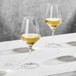 Two Della Luce Astro wine glasses on a marble table