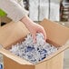 A hand holding a box with Spring-Fill white crinkle cut paper shred.