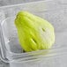 A plastic container of fresh green chayote squash.