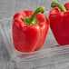 A pair of Fresh Greenhouse Red Bell Peppers in a plastic container.