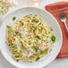 A white plate of Barilla Protein+ angel hair pasta with basil and cheese.