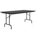 A rectangular Correll black granite folding table with a black frame.