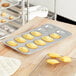 A Gobel Madeleine pan filled with madeleines on a table.