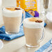 A glass mug of Oregon Chai Organic Original Chai Tea Latte on a white table.