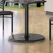 A Lancaster Table & Seating black steel table base on a table in a restaurant dining area.