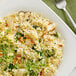 A white plate of Barilla Orzo pasta with a fork.