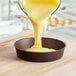 Batter being poured into a Gobel round non-stick cake pan.