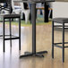 A black Lancaster Table & Seating bar height table base.