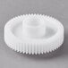 A white Galaxy brush drive gear with a hole on a gray surface.