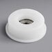 A white plastic wheel with a metal ring and a hole in it.
