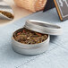 A 2 oz. silver metal tin with a screw top lid.
