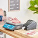 A person weighing meat on an AvaWeigh digital price computing scale.